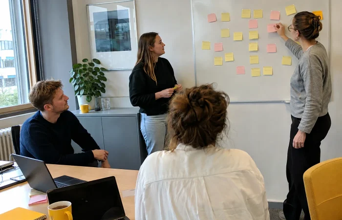 Team prioriteert functionele eisen met memoblaadjes op een whiteboard